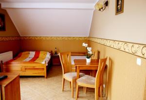 a bedroom with a bed and a table and chairs at Willa Feniks in Łeba