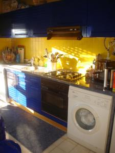 a kitchen with a stove and a washing machine at Tamatramas in Albufeira