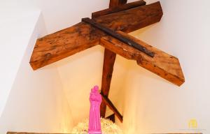 a wooden cross hanging on a wall with a pink vase at Studios with Mezzanine Rua da Moeda in Lisbon +248 photos