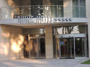 a building with two glass doors and a sign on it at Diune Apartment in Kołobrzeg