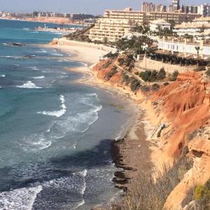Los DolsesにあるOrihuela Costaの建物と海を望むビーチの景色を望めます。