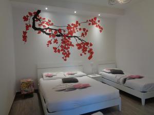 2 Betten in einem Zimmer mit einem Baum an der Wand in der Unterkunft Appartamento Nonna Lina in Custonaci