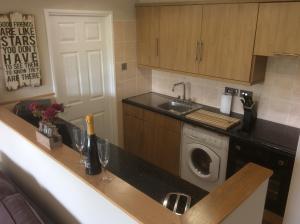 a kitchen with a washer and dryer on a counter at Dawlish Warren Apartments in Dawlish