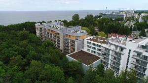 an aerial view of a building with trees and the ocean at Diune Apartment in Kołobrzeg