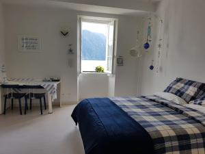 um quarto com uma cama, uma mesa e uma janela em Holy Lake em Ghiffa