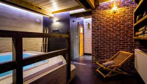 a bathroom with a tub and a brick wall at Aparthotel Pod Nosalem in Zakopane