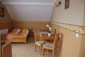 a bedroom with a bed and a table and chairs at Willa Feniks in Łeba