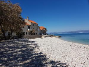 a house on a beach next to the water at Studio apartman Megy in Sutivan +15 photos