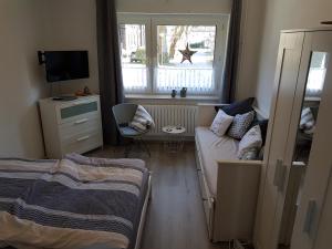 a bedroom with a bed and a couch and a window at Ferienwohnung Bärbel in Essen