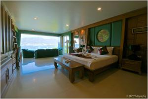 a bedroom with a bed and a living room at Villa REGTUK in Patong Beach