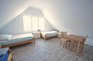 クックスハーフェンにあるAppartement Stader Str. 3のベッド2台、テーブル、窓が備わる客室です。