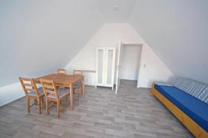 クックスハーフェンにあるAppartement Stader Str. 3のテーブル、椅子、ベッドが備わる客室です。