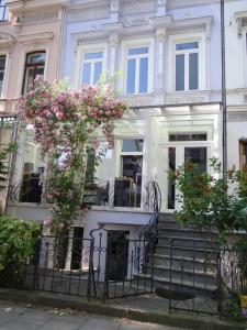 una casa blanca con flores rosas en las escaleras en Temporary living, en Bremen