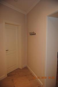 an empty room with a white door and a wooden floor at Schöne Ferienwohnung zentral gelegen in Kiel