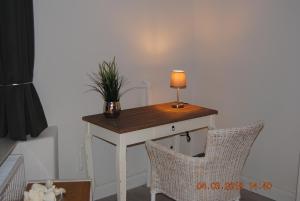 a table with a lamp and a plant on it at Schöne Ferienwohnung zentral gelegen in Kiel