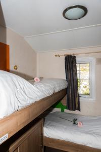 シント・アナラントにあるChaletparc Krabbenkreek Zeeland - Chalet 6の窓付きの客室で、二段ベッド2台が備わります。