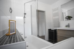 a bathroom with a tub and a shower with a sink at Appartementanlage Wieben in Sankt Peter-Ording