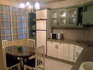 a kitchen with a table and a microwave at Piso Bergantiños in Carballo