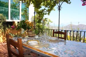een tafel met borden en glazen op een balkon bij Villa Miele in Lipari