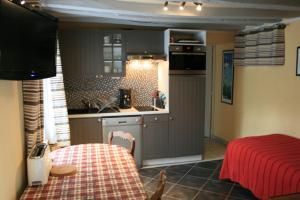 a kitchen with a table and a kitchen with a sink at Gîtes Le Petit Nailly in Magny-les-Hameaux
