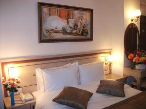 a bedroom with a white bed with two pillows at Sultan Palace Hotel in Istanbul