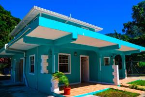 a green house with a blue in der Unterkunft Amazon Villas in Soufrière