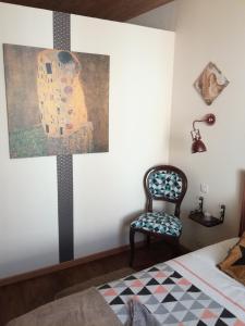 um quarto com uma pintura na parede e uma cadeira em Chez Lorette em Mauzé-sur-le-Mignon