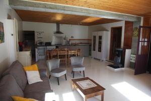 ein Wohnzimmer mit einem Sofa und einem Tisch sowie eine Küche in der Unterkunft La Truelle in Seyne