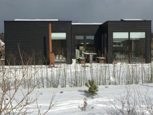 una casa negra en la nieve delante en Wadzand en Midsland