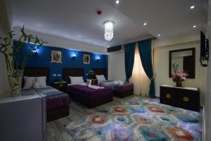 a bedroom with two beds and a large rug at Amin Hotel in Cairo