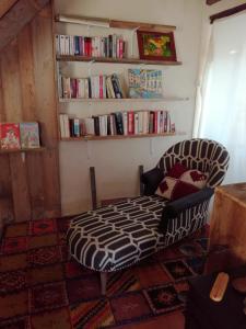 una camera con divano e libreria con libri di Chez Lorette a Mauzé-sur-le-Mignon
