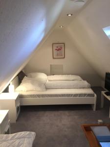 a bedroom with a white bed in the attic at Heaven in Winterberg