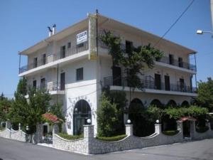 un grand bâtiment blanc avec des plantes devant lui dans l'établissement Villa Kalavrita Hotel, à Kalavrita