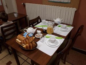 ポントルソンにあるHôtel Le Lithanaのパンとオレンジジュースの朝食付きテーブル