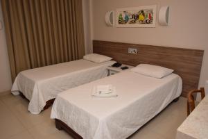 Un pat sau paturi într-o cameră la Hotel Gramado de Campos