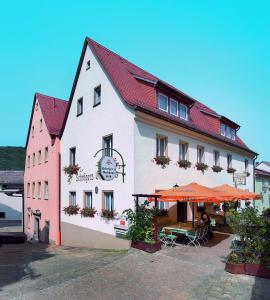 un edificio con un paraguas naranja delante de él en Pension Schrägers, en Königstein