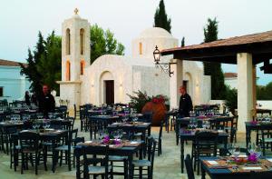 a group of tables and chairs in front of a building at Anassa in Polis Chrysochous