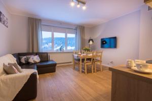 a living room with a couch and a table at Apartament Słoneczny in Ustrzyki Dolne