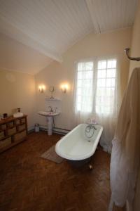 baño con bañera y ventana en The Retreat @ Le Grand Bois, en Miramont-de-Guyenne