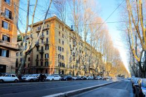 eine Straße mit Autos, die an der Seite eines Gebäudes geparkt sind in der Unterkunft Relais Incantesimo Vaticano in Rom