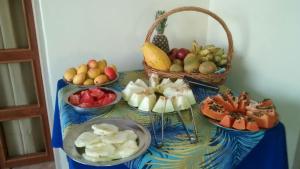 a table with bowls of fruit and a basket of fruit at Casa da Ponte Hotel in Goiás