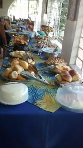 a long blue table with plates of food on it at Casa da Ponte Hotel in Goiás