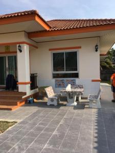 a house with a patio and a table and chairs at Janson's House in Ban Mae Kon