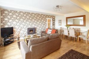a living room with a couch and a tv and a table at Host & Stay - View Point Apartment in Hinderwell