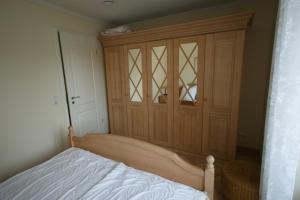 キュールングスボルンにあるVilla Metropolのベッドルーム1室(ベッド1台付)、木製キャビネットが備わります。