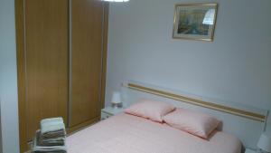 トレビエハにあるApartamento frente de la playaのベッドルーム1室(ピンクの枕が付いたベッド1台付)