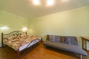 キーウにあるIordanska Street Apartmentsのベッドルーム1室(ベッド2台、ソファ付)