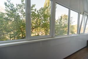 a row of windows in a room with trees at Iordanska Street Apartments in Kyiv