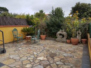 um pátio com cadeiras e uma mesa e algumas plantas em Villa Luisa Apartment em Somo