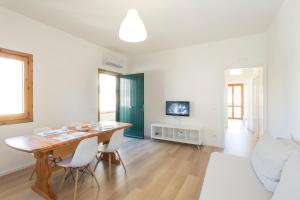 a living room with a table and chairs and a television at BOBO' in Marina di Ragusa